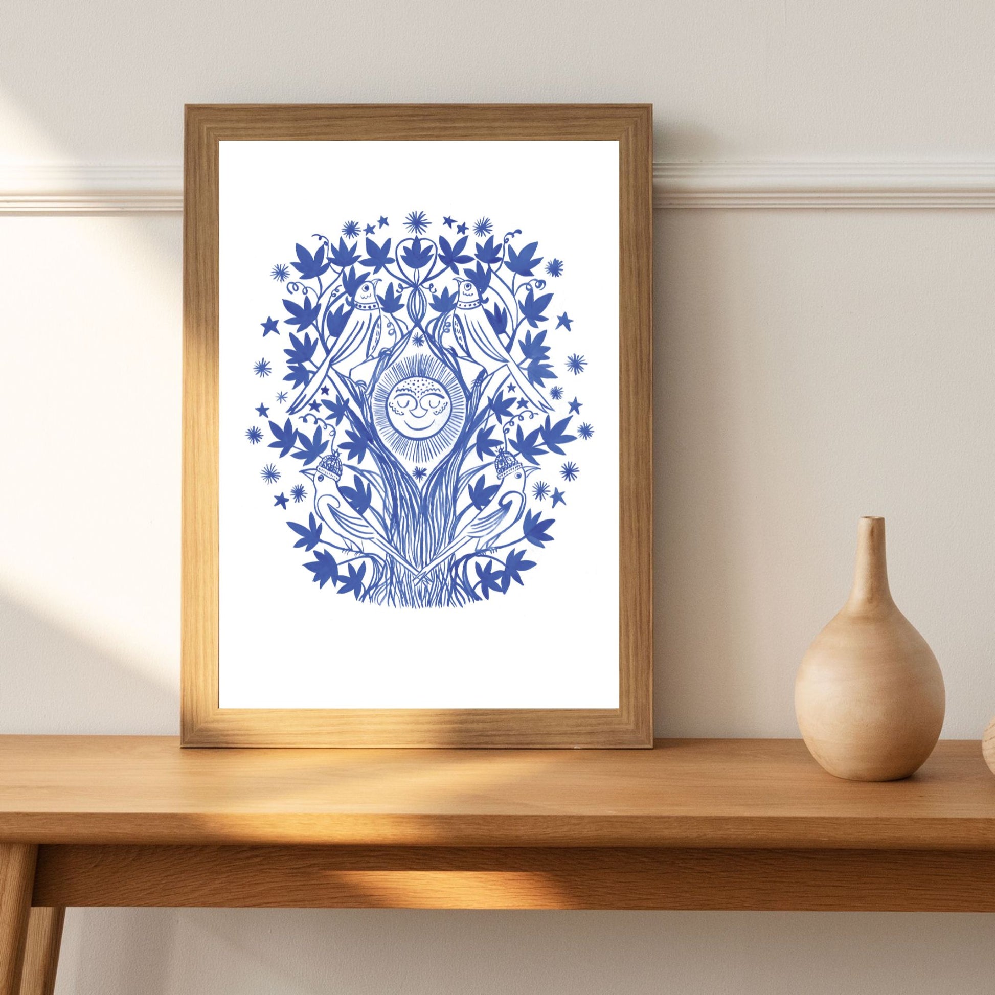Framed blue and white artwork on a wooden shelf with a vase.