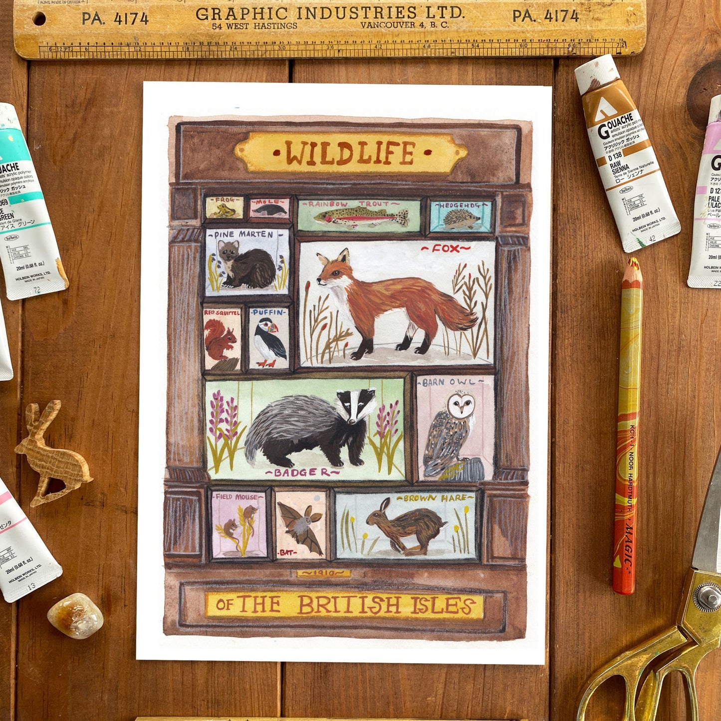 Illustration of wildlife of the British Isles on a wooden surface with art supplies.