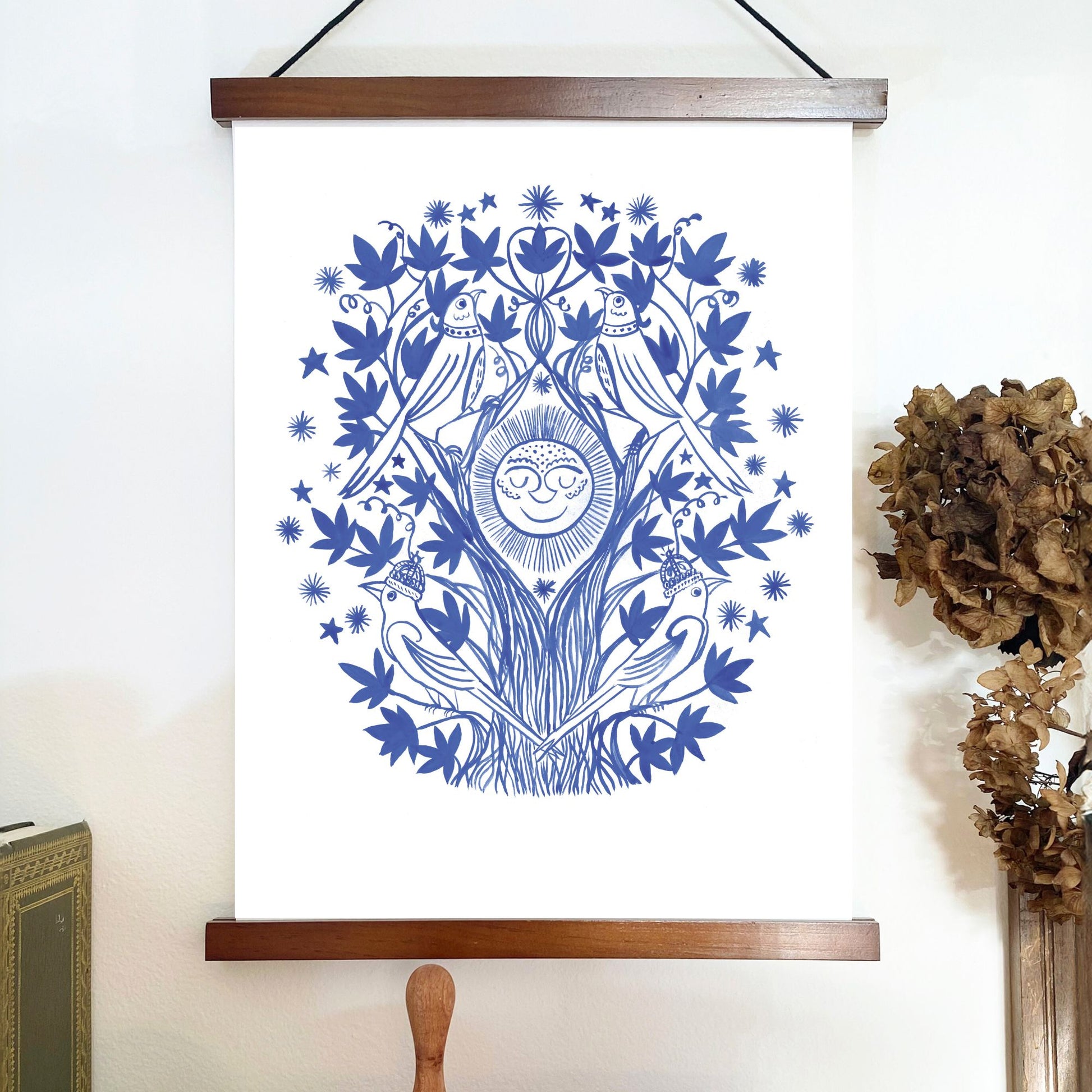 Decorative wall art with blue floral and bird design on a white background, mounted on a wooden frame.