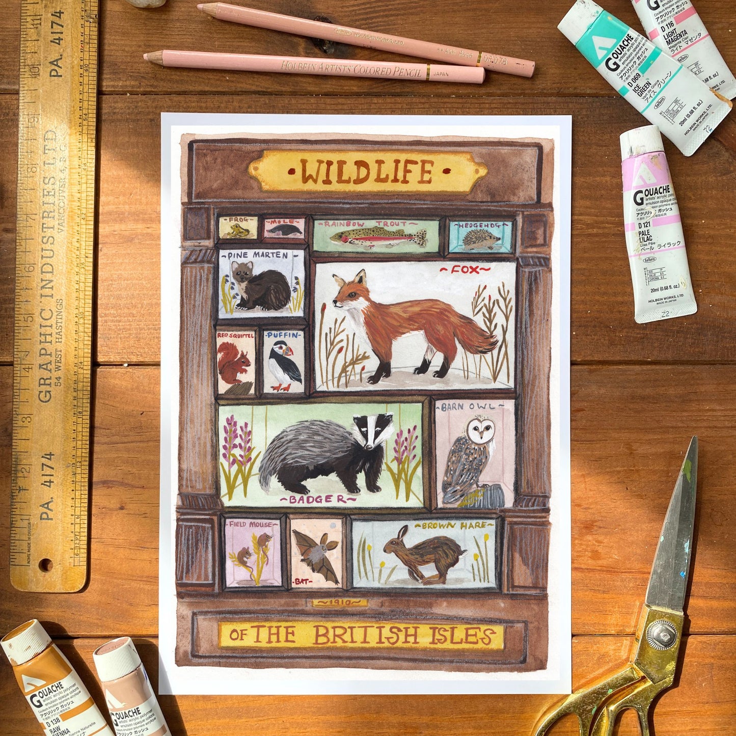 Illustration of wildlife of the British Isles on a wooden surface with stationery items.